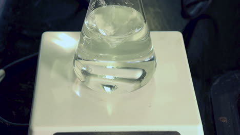 close up of clear liquid in erlenmeyer flask on a magnetic stirrer