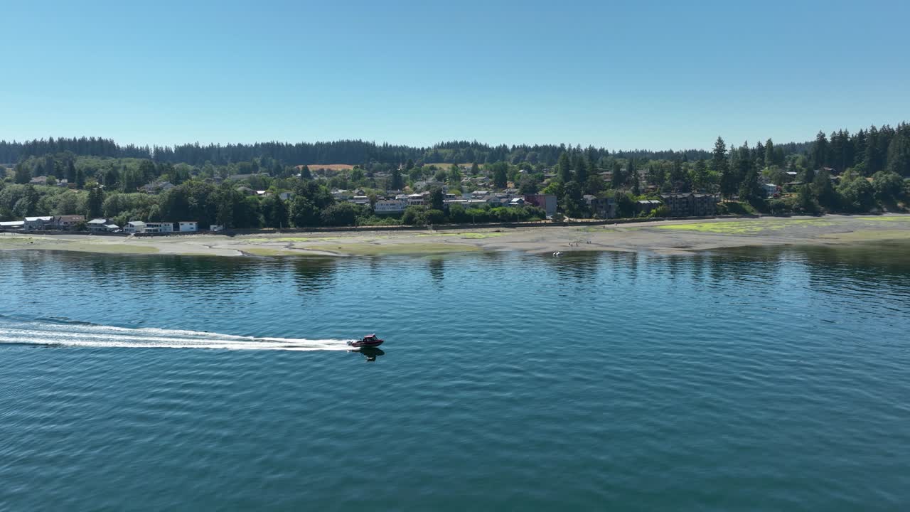 toma aérea de una lancha que pasa por la ciudad de langley en la isla whidbey