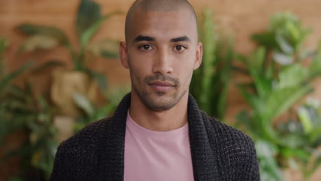 portrait of confident mixed race man looking serious independent student handsome bald male plants background slow motion