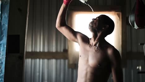 boxeador vertiendo agua en su cara en el gimnasio