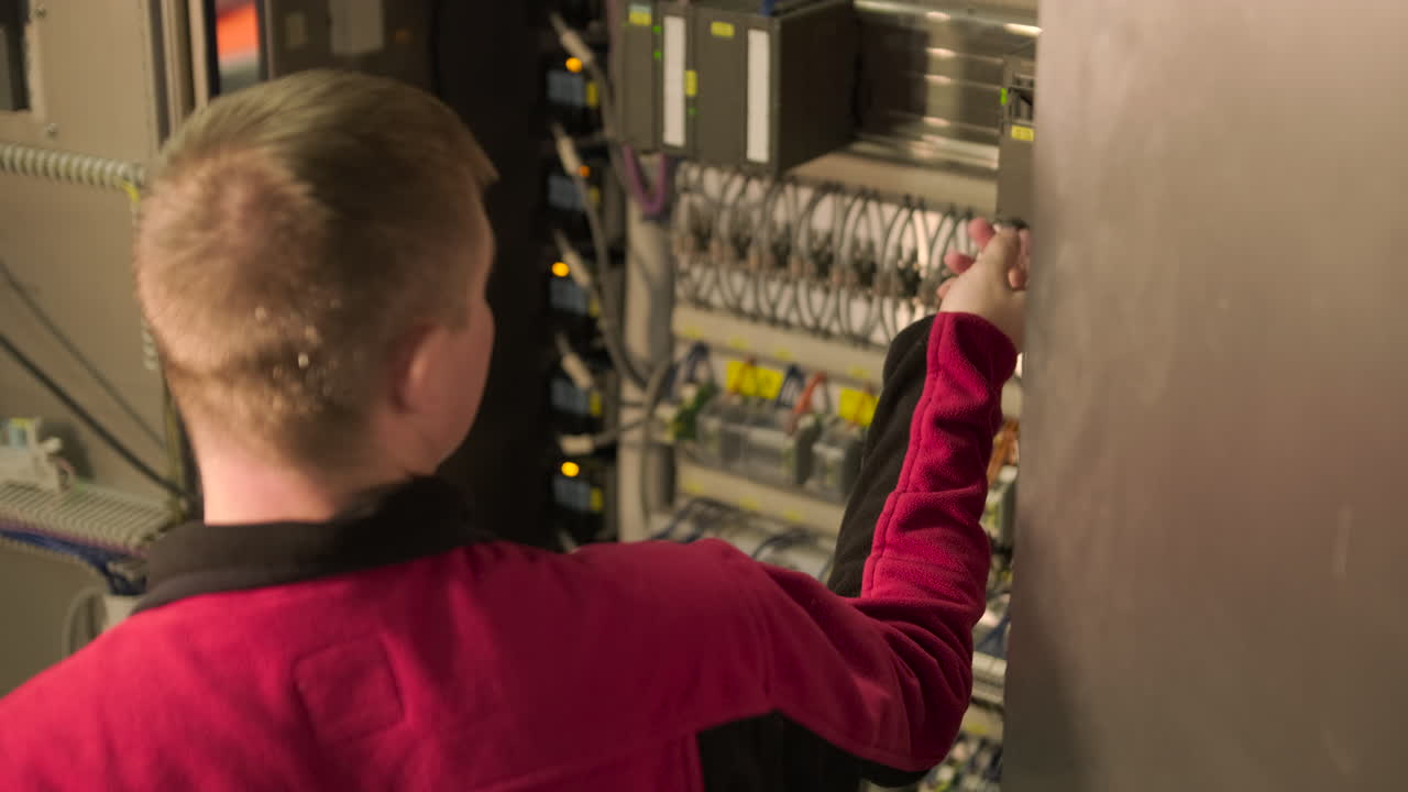 Engineer Inspecting and Adjusting an Industrial Electrical Control Panel