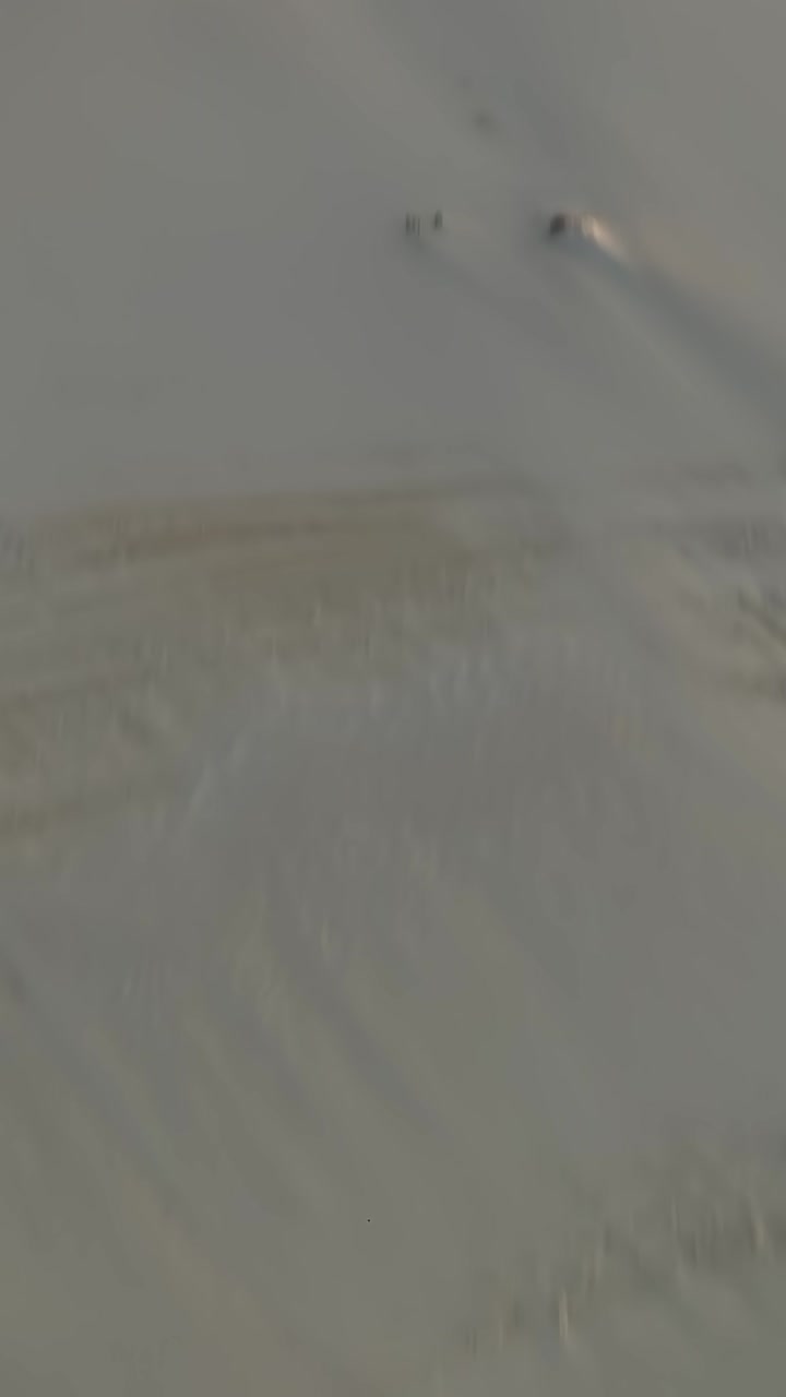 Couple Walking on a High Sand Dune Ridge with Shadows
