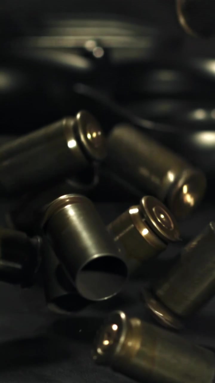 Bossoli d'ottone che cadono al rallentatore su uno sfondo scuro