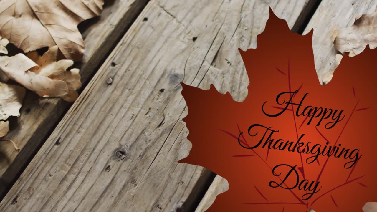 Animation du texte Joyeux Jour de Thanksgiving sur une feuille d'automne sur fond de planches en bois