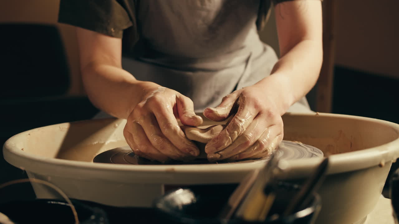 persona que da forma a la arcilla en una rueda de cerámica