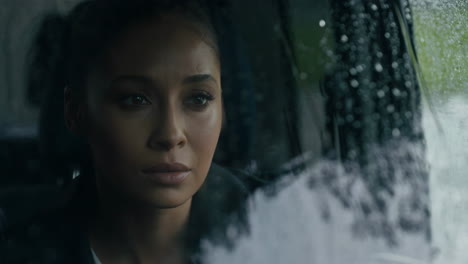woman looking out a rainy car window