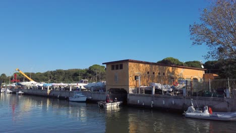 Motorboat-entering-a-covered-slipway-in-Borghetto-dei-pescatori,-a-little-neighborhood-of-Lido-di-Ostia-in-the-city-of-Rome,-Italy