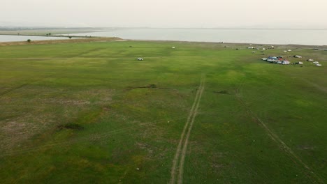 Aerial-view-shot-of-Landscape-at-the-end-of-Pa-Sak-Jolasid-Dam-with-green-grass-and-water