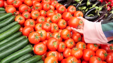 mujer comprando tomates en un mercado