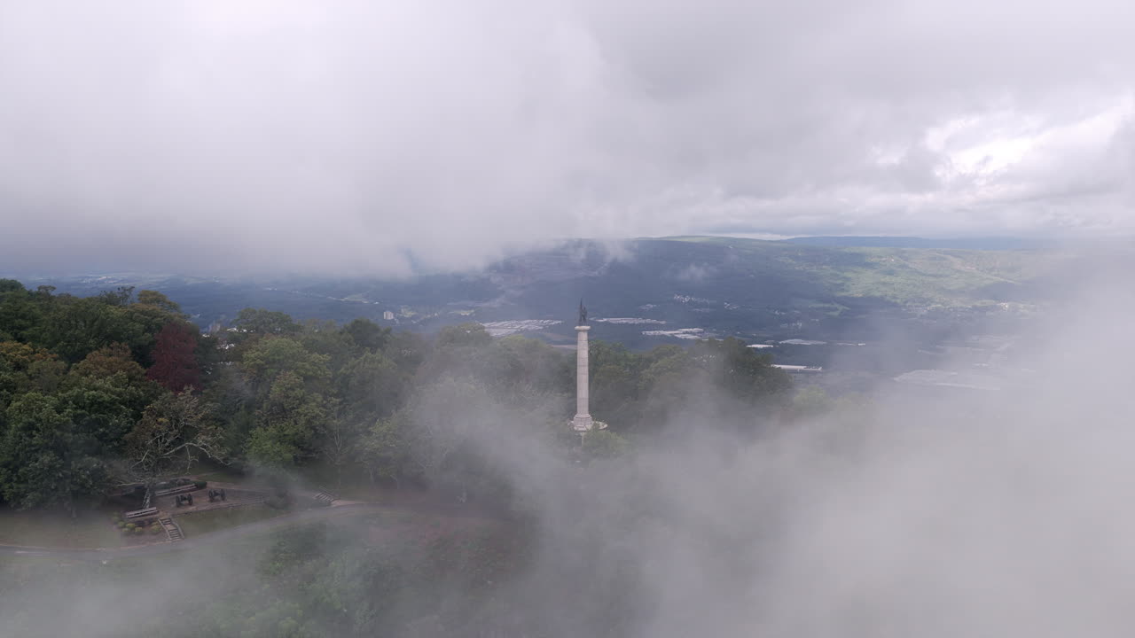 A dramatic drone shot shows the Point Park statue framed by swirling fog with sweeping views of Lookout Mountain and the valley beyond