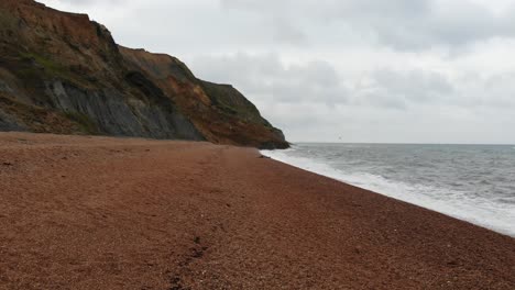 Luftaufnahmen-Fliegen-Tief-über-Seatown-Beach-In-Dorset-Mit-Großen-Küstenerdrutsch-Im-Hintergrund