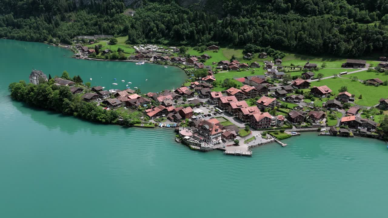 Aerial of Iseltwald at the turquoise lake Brienzersee and Castle Seeburg surrounded by its beutiful green nature in Switzerland europe also showing the filmspot pier of crash landing on you