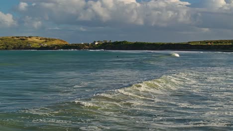 Aerial-tracking-pan-follows-ocean-wave-breaking-into-whitewash