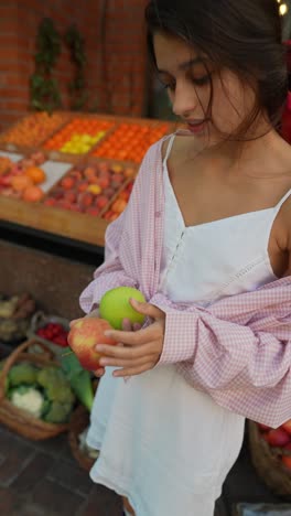mujer comprando frutas en un mercado
