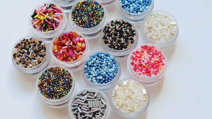 beads and bugles close-up . Handicraft and hobby concept. set of beads. Colored beads in round boxes set.