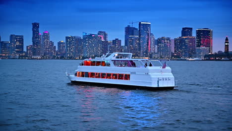 numerous people travel by the modern riverboat at dusk time. modern skyline of new york at backdrop