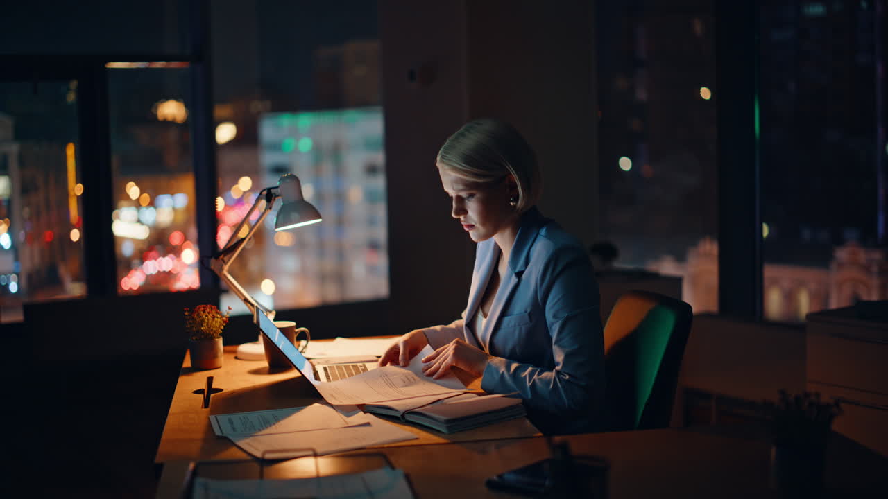 Businesswoman working late evening in office. Hardworking manager typing laptop