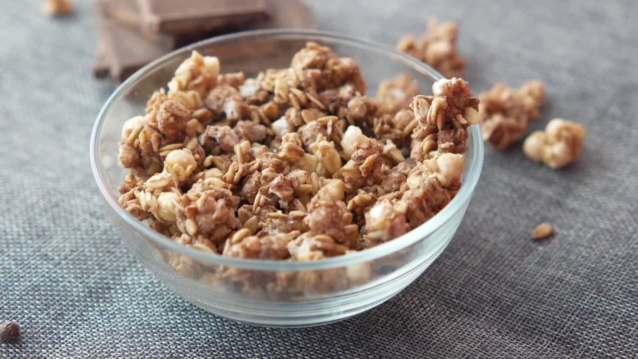 agarrando con la mano la granola de un cuenco