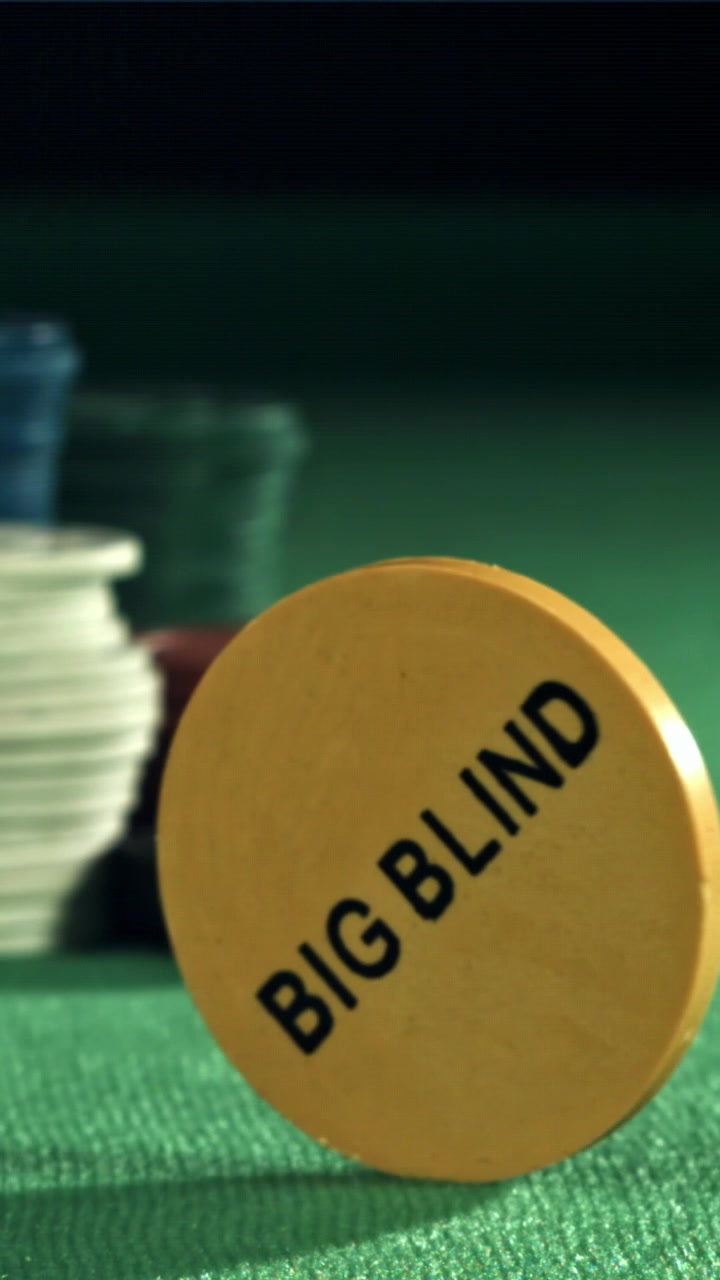 Fiches da poker gialla 'Big Blind' che gira su un tavolo di feltro verde