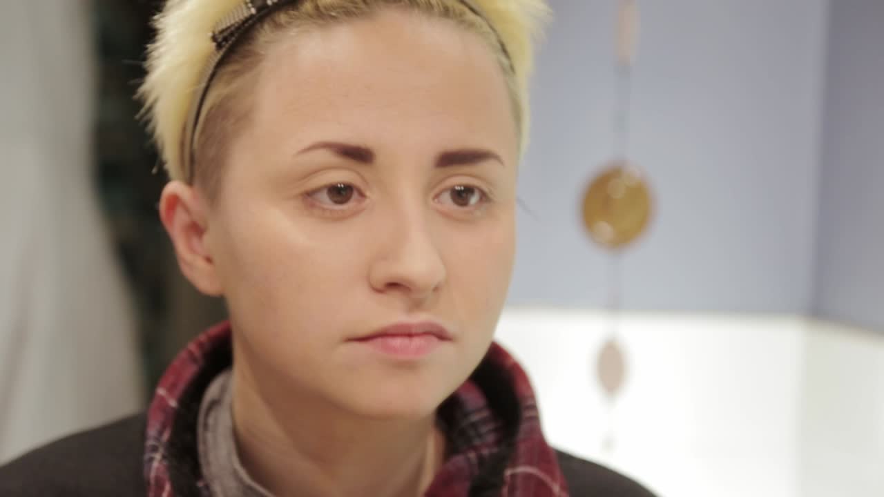 한 젊은이가 거울을 보고 눈썹을 손질한다