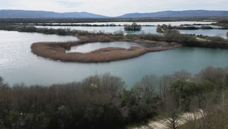 Blattlose-Bäume-Und-Hohes-Schilf-In-Flusslage-Schaffen-Abgeschiedene-Teiche.-Antike-Lagune-Von-Antela,-Areeiras-Da-Limia-In-Xinzo-De-Limia,-Ourense,-Galizien,-Spanien