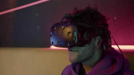 close up view of boy playing video games wearing virtual reality glasses sitting on sofa at home