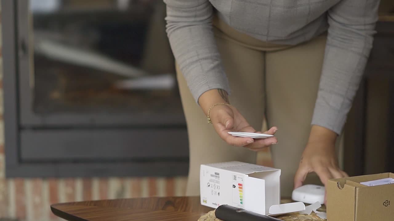 mujer instalando un control magnético de la luz led que compró, en la sala de estar