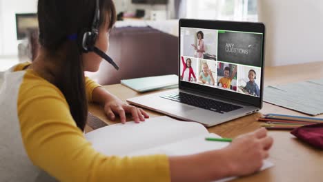 Schoolgirl-using-laptop-for-online-lesson-at-home,-with-diverse-teacher-and-class-on-screen