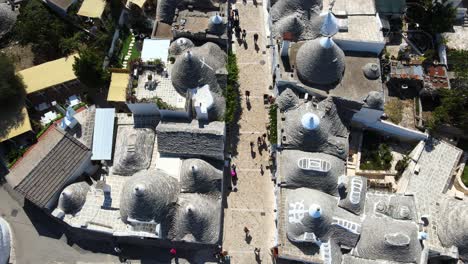 Toma-Aérea-De-Drones-De-Pequeñas-Calles-Peatonales-Alrededor-De-Alberobello,-Italia