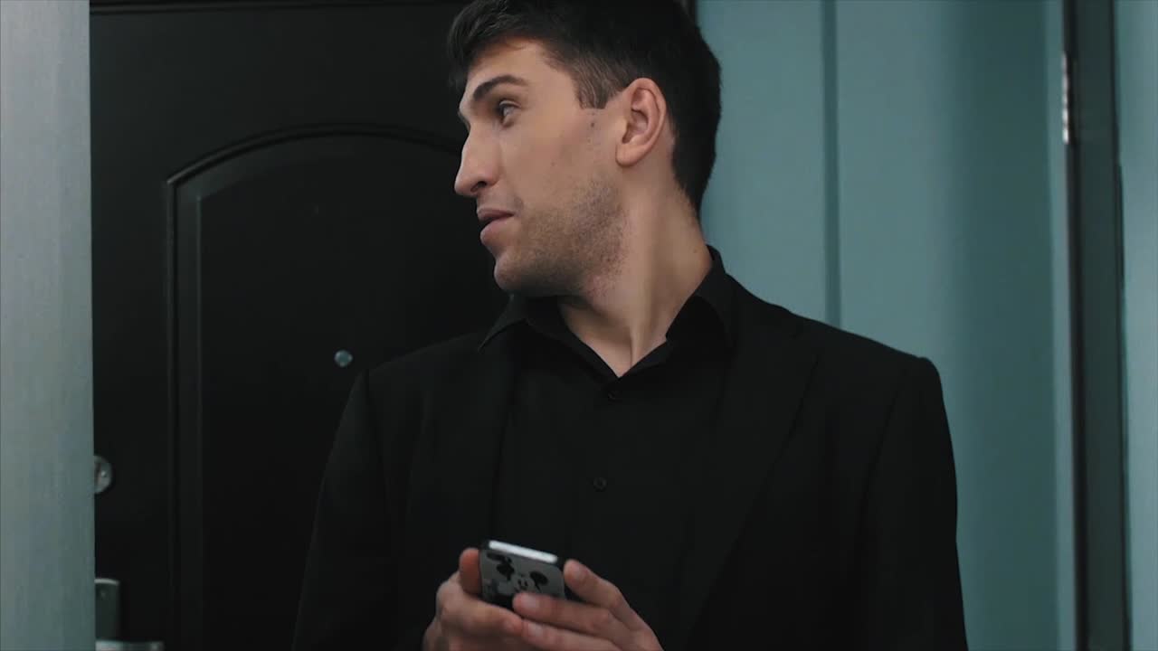 복도에서 문자 메시지를 보내는 남자