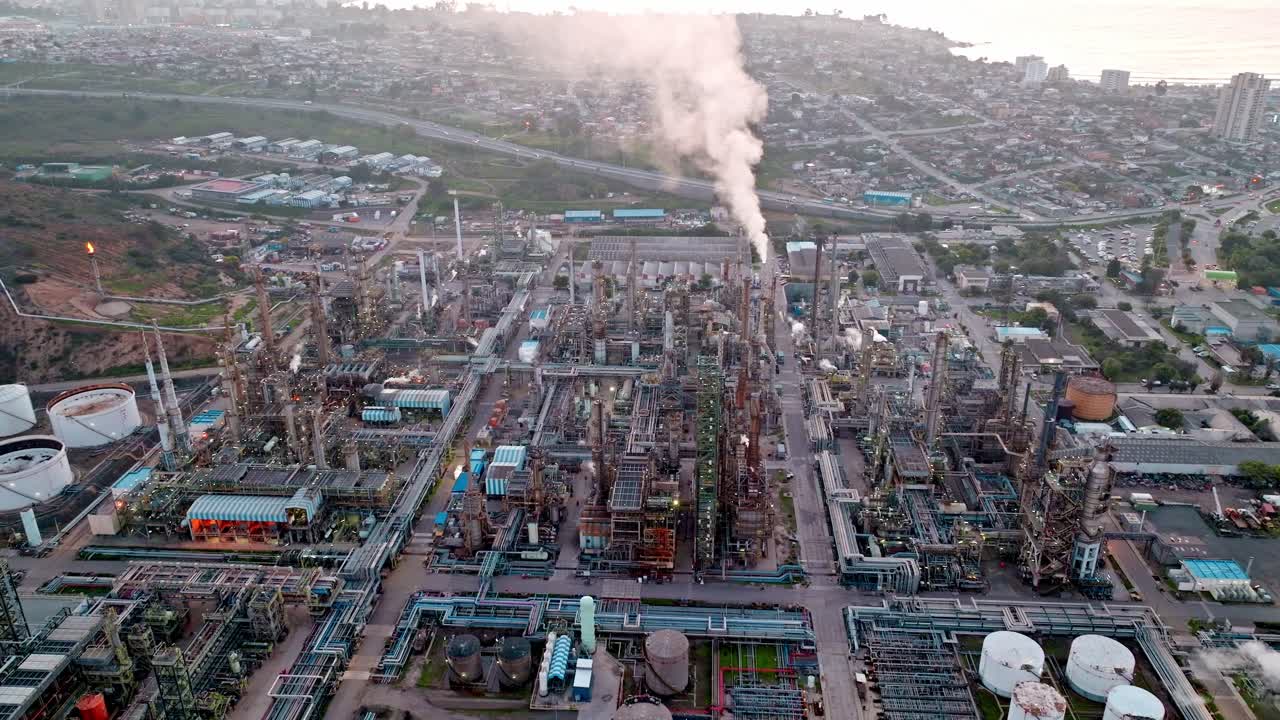 órbita aérea de una refinería de petróleo con puesta de sol en el fondo