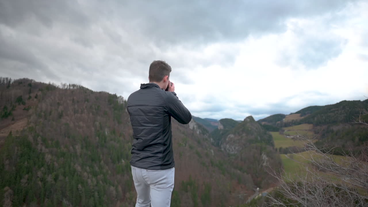 Man Walking on a Rock with a beautiful View, Taking a Picture of the Landscape, Slow-Motion
