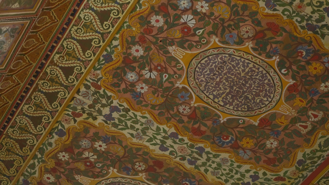 Ornate painted ceiling with traditional Moroccan floral patterns in Marrakesh interior