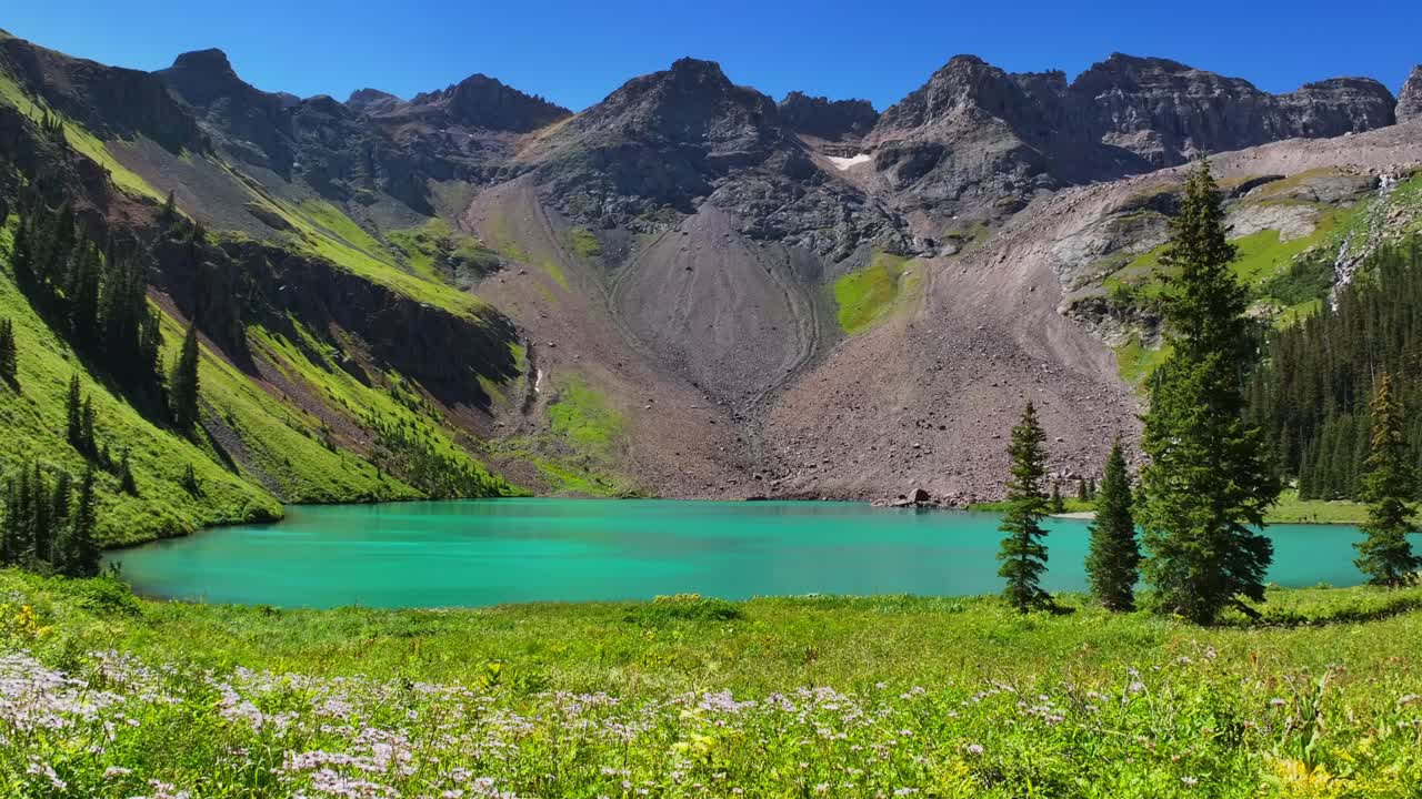 Lower Blue Lake Mount Sneffels Wilderness beautiful sunny morning Ridgway Telluride Colorado aerial drone San Juan Rocky Mountains Dallas Range wildflowers blue sky hiking trails static shot