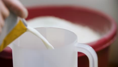 pouring milk into a measuring cup