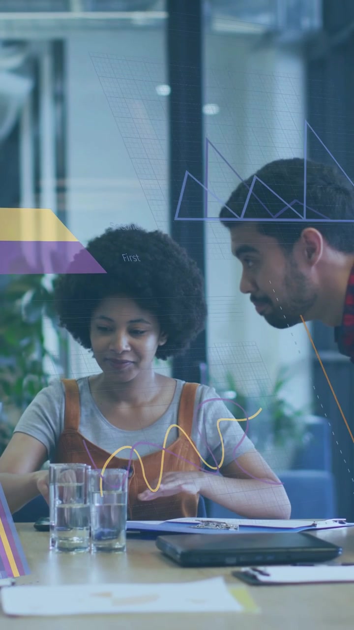 Vertical video: Woman picking folder, flipping while peer leaning in, charts showing business data