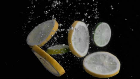 lemon slices falling into water super slowmotion, black background, lots of air bubbles, 4k240fps