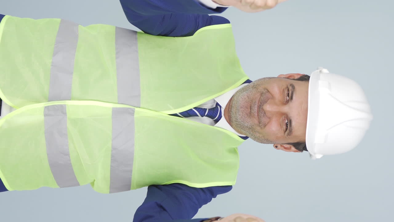 vídeo vertical del ingeniero haciendo una señal de confianza a la cámara.
