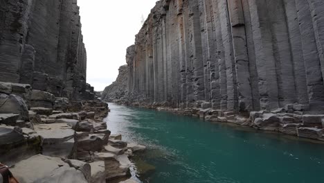 Studlagil-Magníficas-Formaciones-Rocosas-Que-Rodean-Un-Hermoso-Río-Azul