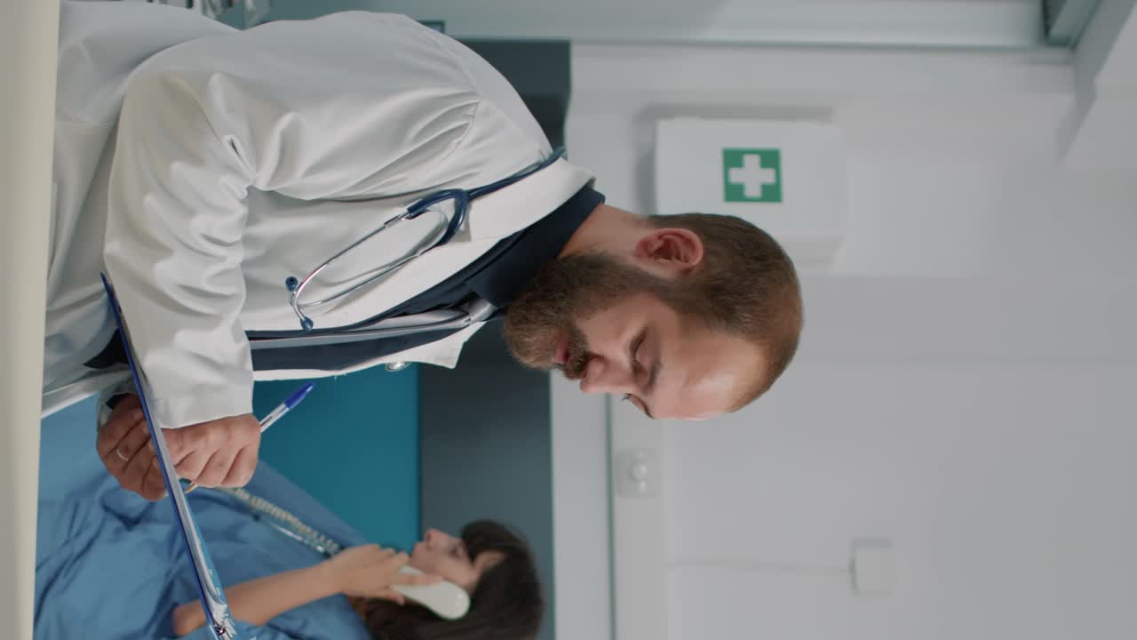 Male physician taking notes and consulting elder person