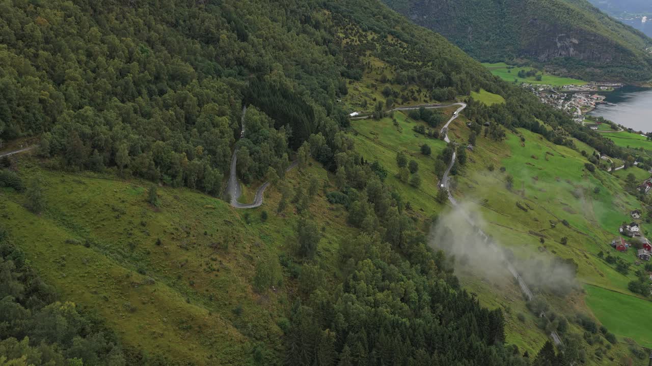 Droneopptak av bobil som navigerer krappe svinger langs Aurlandsfjordens klipper i Norge