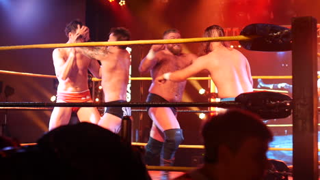 group of wrestlers eye gouging with intense grappling moves in the wrestling ring, with each fighter attempting to gain control.