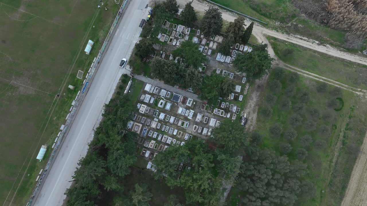 Territorial planning in a small Greek village. Long shot over the local cemetery and soccer field