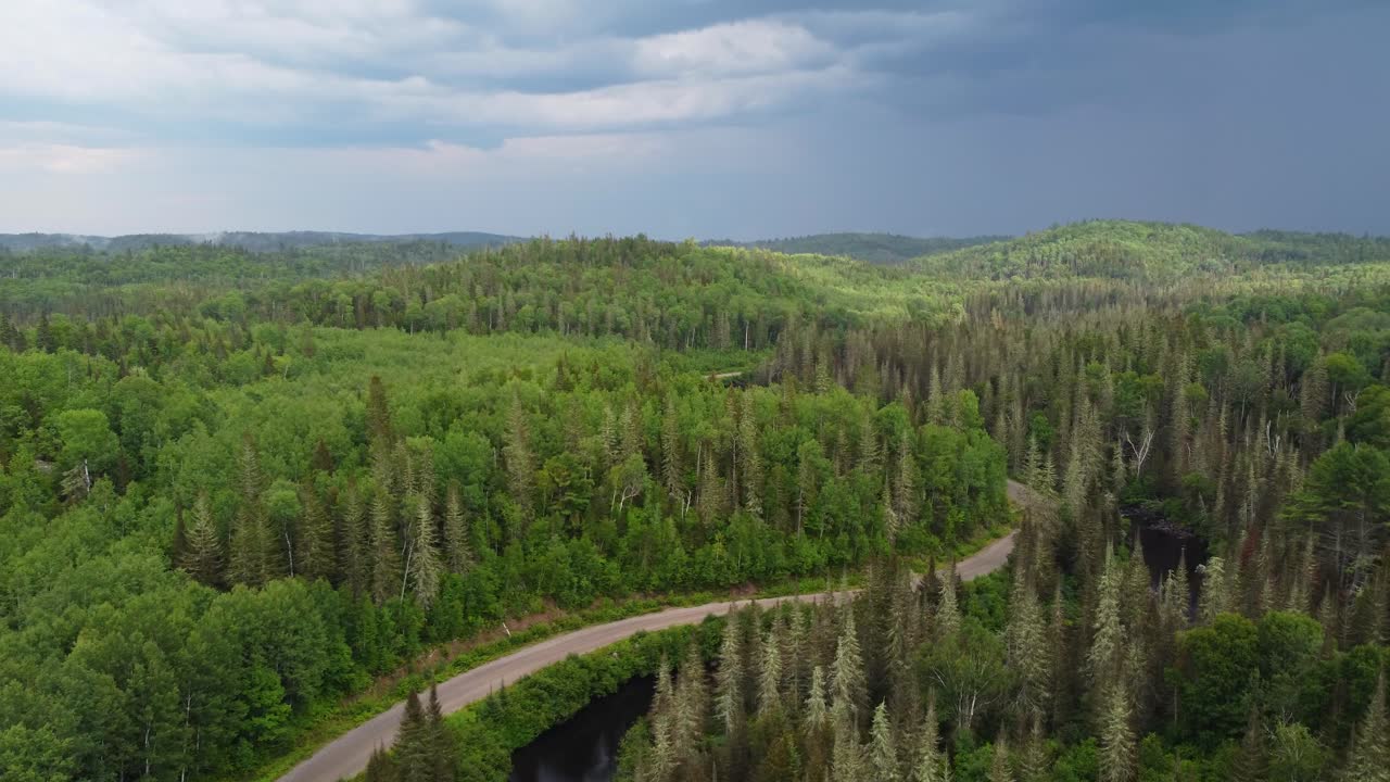 캐나다 온타리오 주 무스코카 에 있는 아름다운 자연 숲 에 둘러싸인 멀리 떨어진  ⁇ 은 도로 위 를 날아다니는 공중 드론 촬영