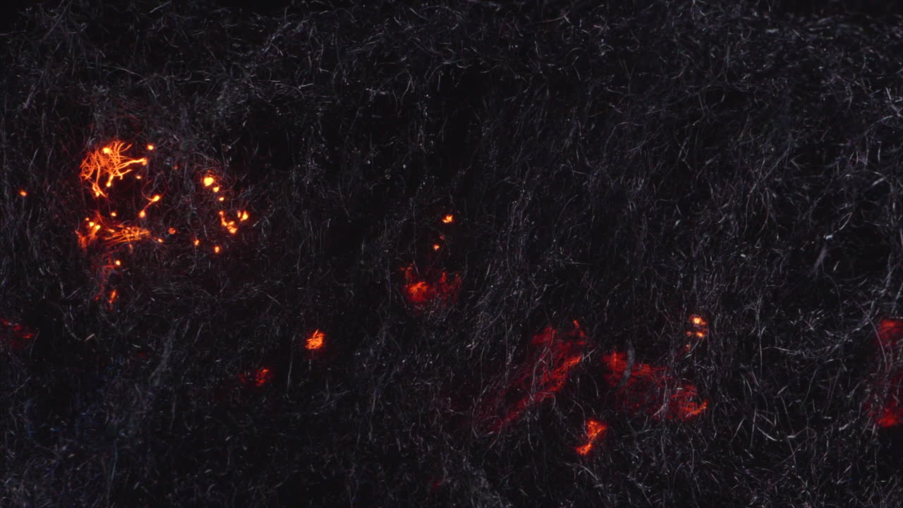 Orange embers moving in steel wool fibers -slow motion