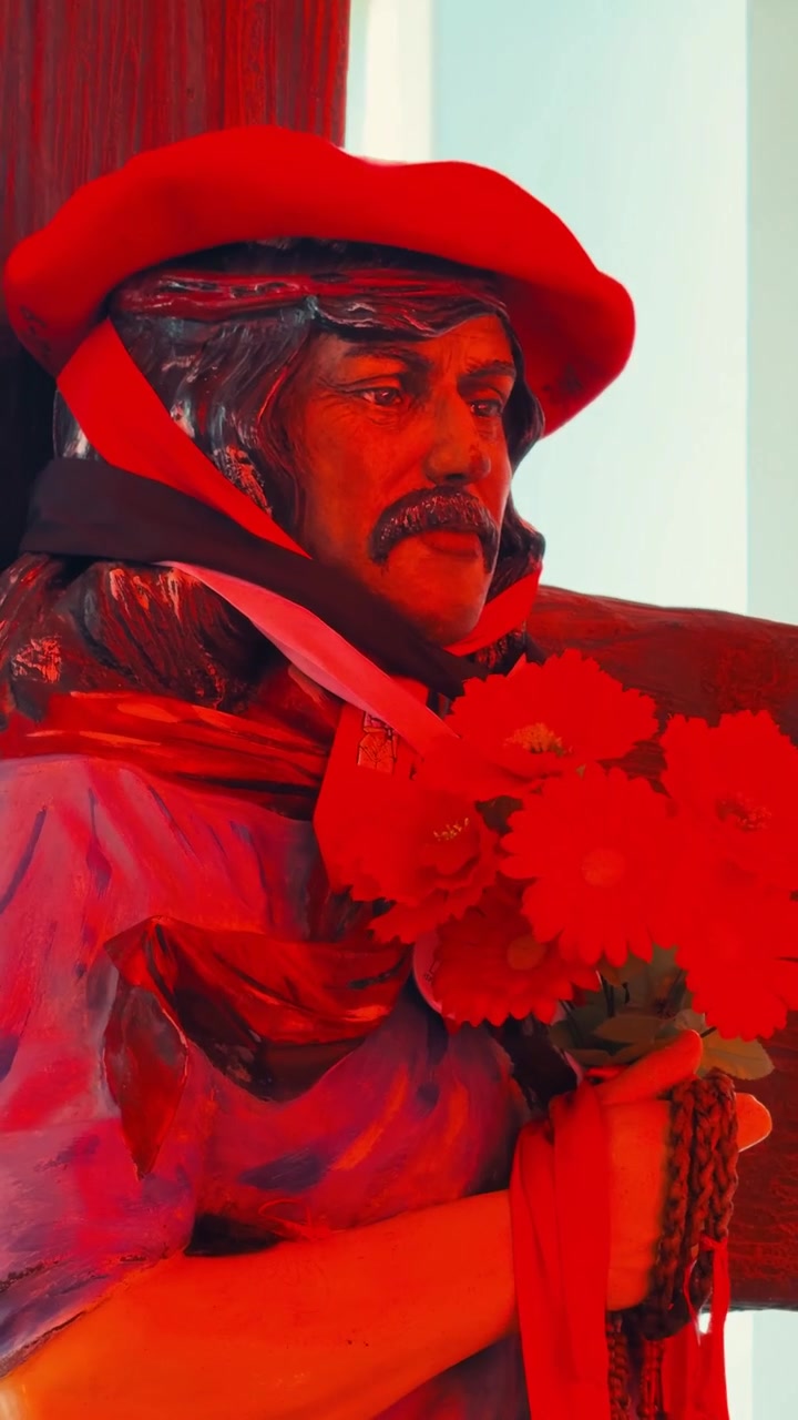 Scultura artistica di un uomo con baffi e fiori rossi