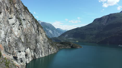 Aerial-view-passing-a-steep-mountain-wall-in-Storfjorden,-Norway---rising,-drone-shot