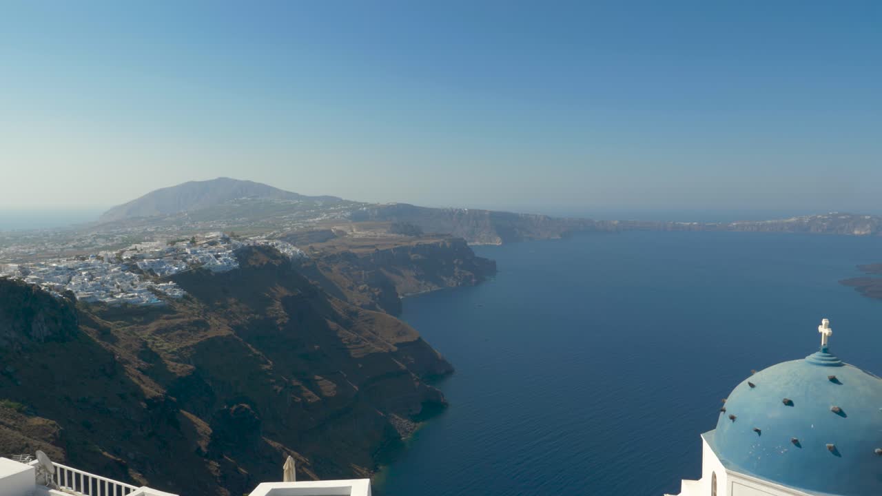 vista panorámica sobre la icónica caldera y la iglesia azul en la azotea santorini grecia