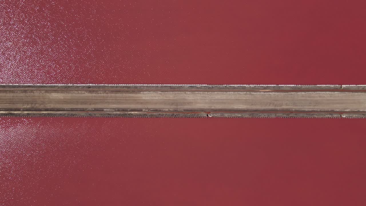 vista del lago rosa brillante desde arriba siguiendo un camino largo y estrecho