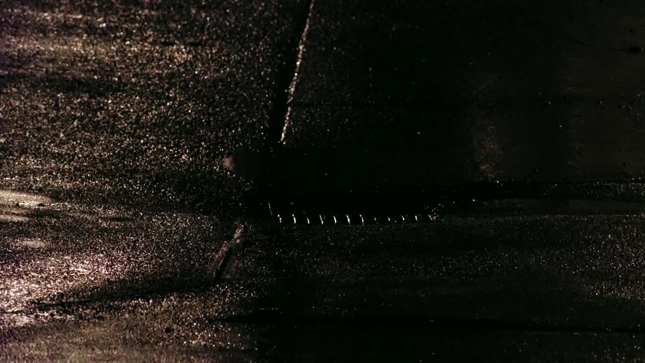 puerta de la parrilla de alcantarillado en la noche húmeda y lluviosa